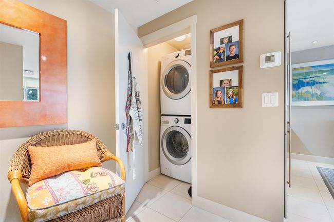 Laundry room with baseboards, stacked washing maching and dryer, laundry area, and light tile patterned floors | Image 6