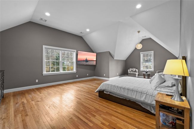 Bedroom featuring wood finished floors, baseboards, multiple windows, and visible vents | Image 24