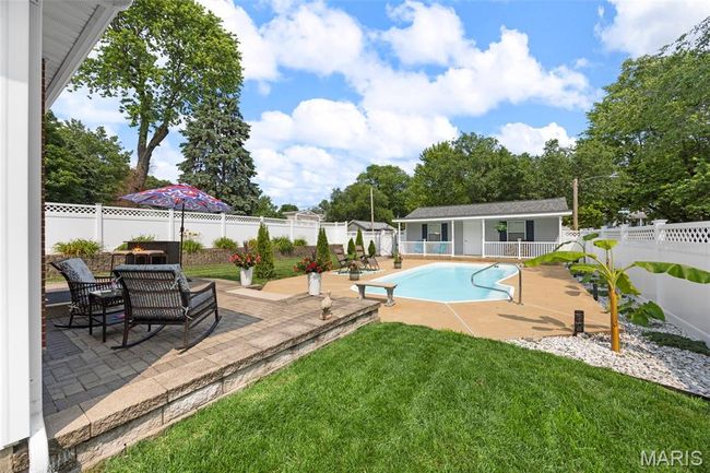View of pool with a fenced backyard, a patio area, and an outdoor structure | Image 38