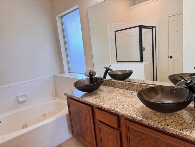 Full bath with a stall shower, a whirlpool tub, and double vanity | Image 10