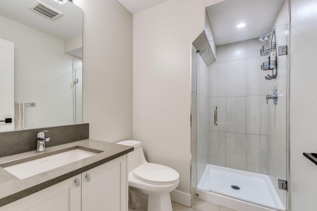 Bathroom featuring toilet, a stall shower, and visible vents | Image 17