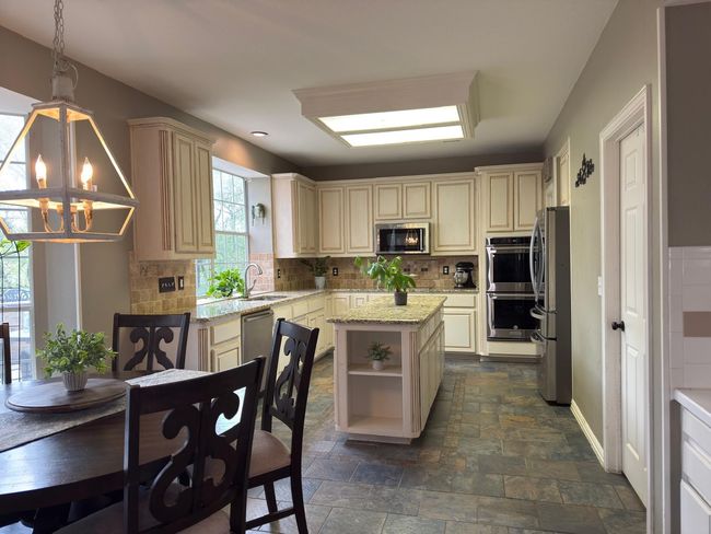 Dining room with stone tile flooring and baseboards | Image 8