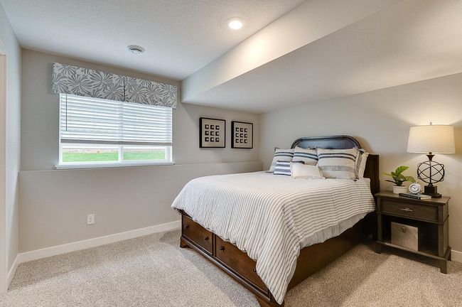 The lower level also includes this large bedroom, which has its own walk-in closet and immediate access to a full bathroom. Photo of model, colors and options will vary. | Image 22