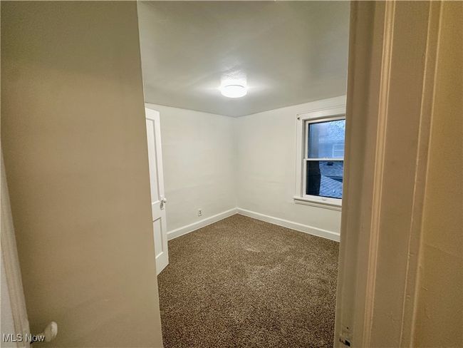 Spare room with dark carpet and baseboards | Image 20