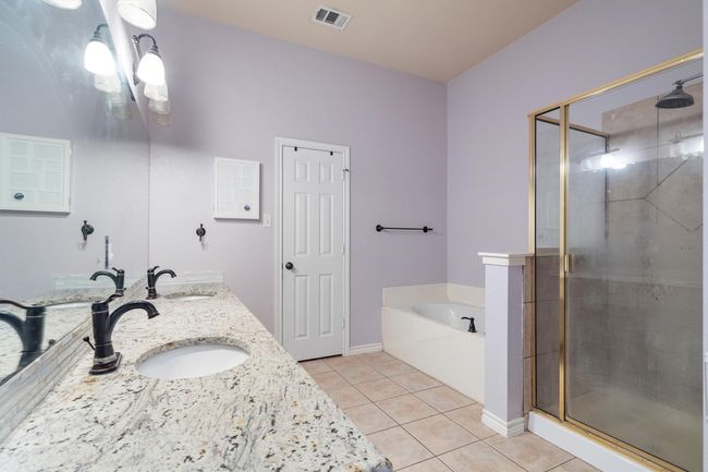 Full bathroom featuring tile patterned floors, a shower stall, a garden tub, and double vanity | Image 26