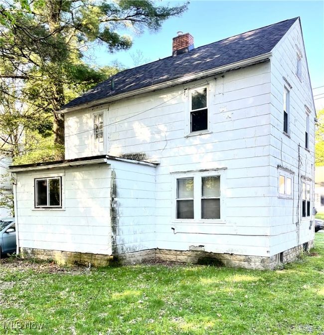 Rear view of house with a lawn, a chimney, and a shingled roof | Image 22
