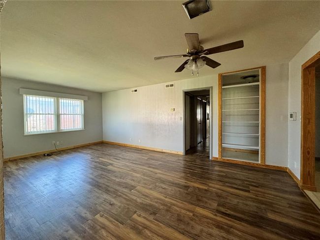 Spare room featuring dark wood-type flooring and ceiling fan | Image 13