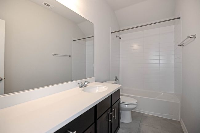 Full bath with tile patterned floors, toilet, vanity, shower / bathing tub combination, and visible vents | Image 32