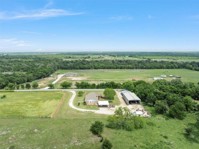 Aerial view of sparsely populated area featuring a heavily wooded area | Image 37