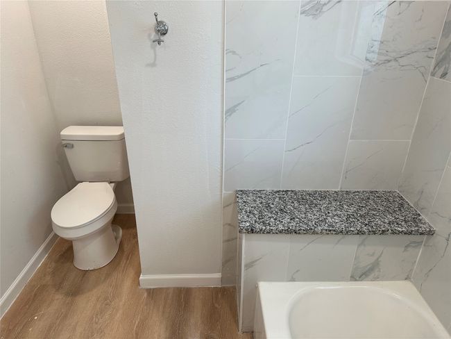 Bathroom featuring wood finished floors, toilet, and baseboards | Image 9