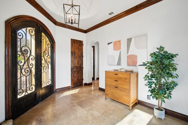 Foyer with arched walkways, visible vents, french doors, and a chandelier | Image 7