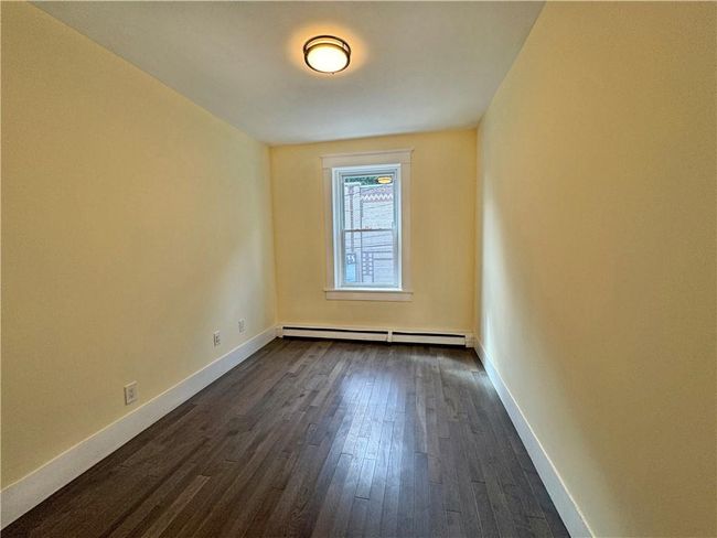 Spare room with a baseboard heating unit and dark hardwood / wood-style flooring | Image 11
