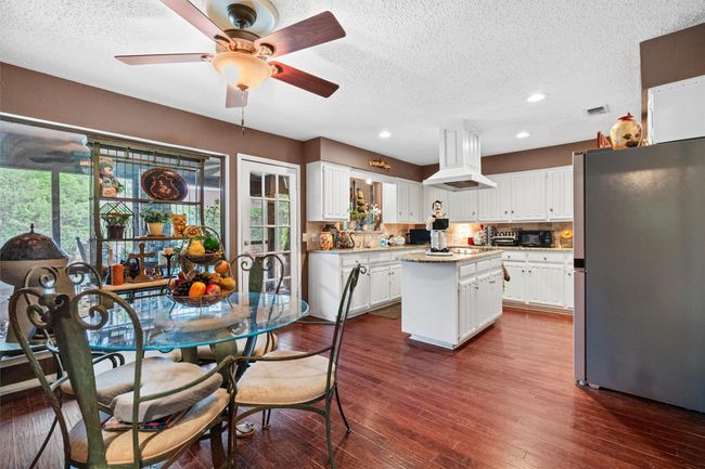 Dining area featuring recessed lighting, a textured ceiling, dark wood-style floors, and ceiling fan | Image 6