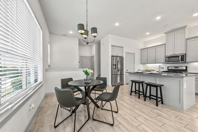 Dining space featuring a notable chandelier and light wood-type flooring | Image 14