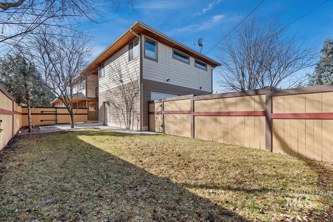 Rear view of property featuring a fenced backyard, a garage, and a patio | Image 10