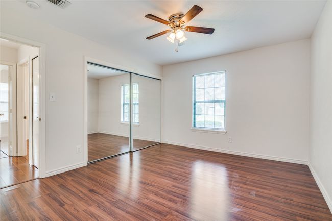 Unfurnished primary bedroom featuring wood finished floors, a closet, and a ceiling fan | Image 17