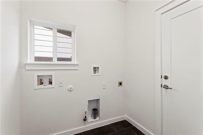 Laundry area featuring hookup for a gas dryer, hookup for an electric dryer, washer hookup, and dark tile patterned floors | Image 15