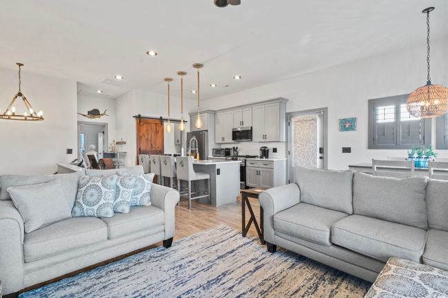 Living room featuring recessed lighting, a notable chandelier, and a barn door | Image 13