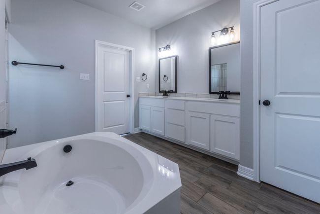 Bathroom featuring double vanity, a tub to relax in, and wood finished floors | Image 14