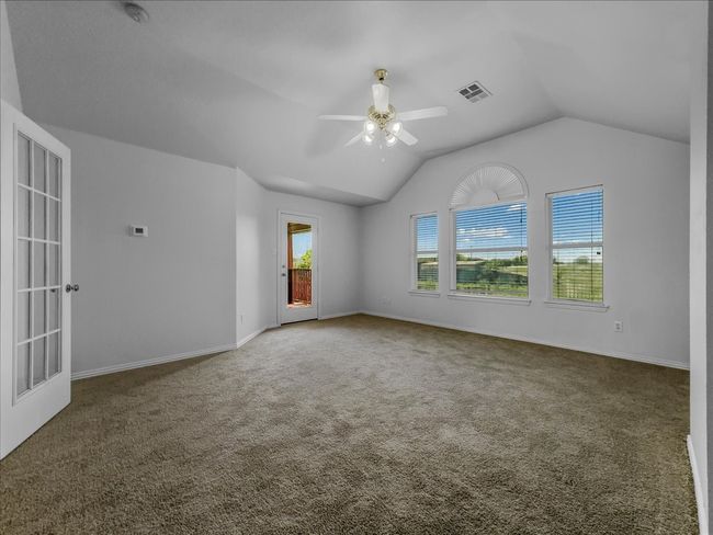 Carpeted empty room with ceiling fan and lofted ceiling | Image 18