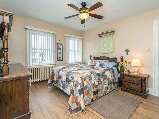 Bedroom featuring radiator, wood finished floors, and ceiling fan | Image 9