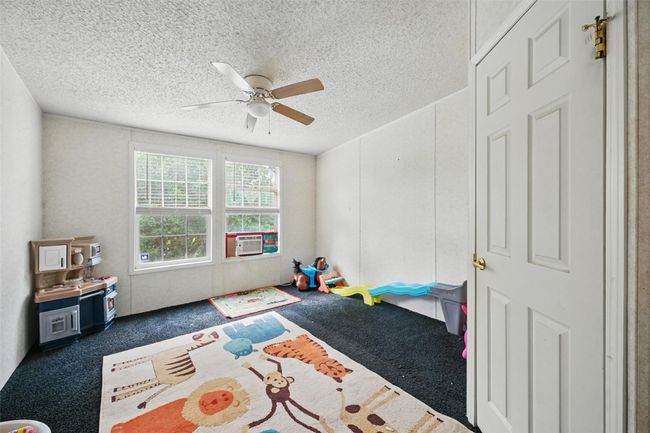 Rec room featuring carpet floors, a textured ceiling, ceiling fan, and cooling unit | Image 15