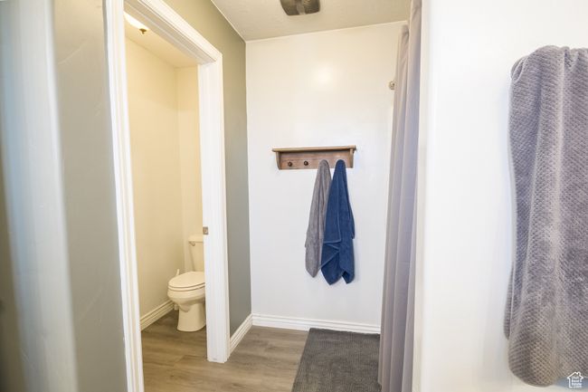 Full bath featuring wood finished floors, toilet, and baseboards | Image 14