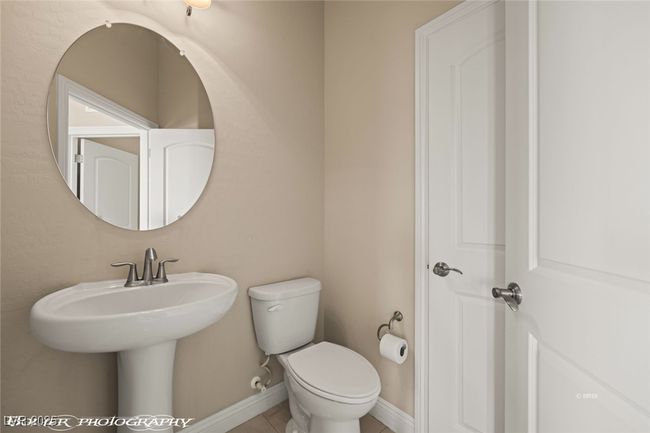 Half bath featuring tile patterned flooring, baseboards, a sink, and toilet | Image 33