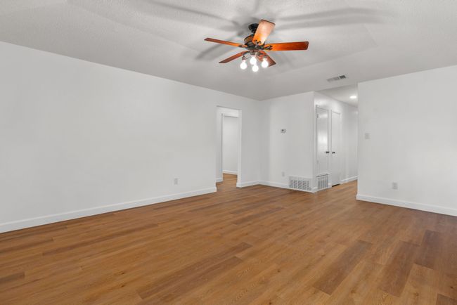 Empty room featuring ceiling fan and light wood-style floors | Image 13
