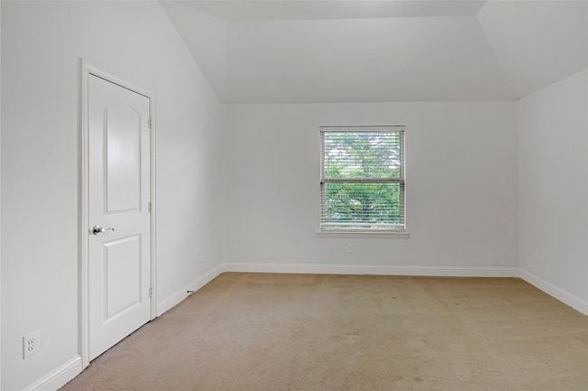 Carpeted spare room featuring lofted ceiling | Image 31