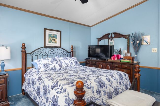 Carpeted bedroom featuring vaulted ceiling, ornamental molding, and ceiling fan | Image 36