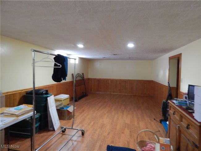 Rec Room featuring a textured ceiling, wooden walls, and wainscoting | Image 24