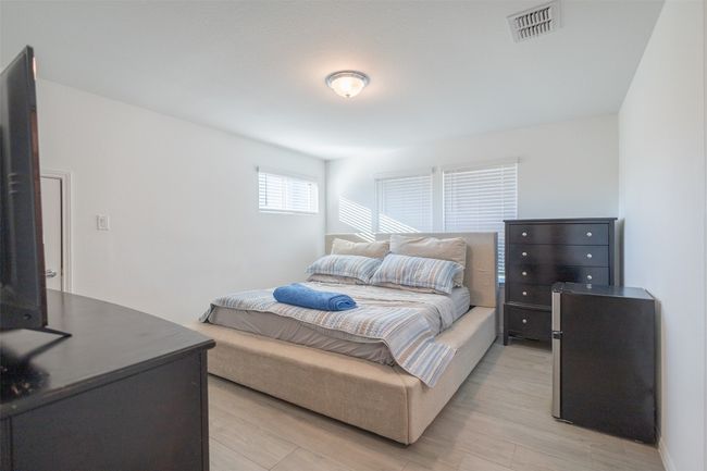 High ceilings, several windows, and tile flooring in this bedroom. | Image 27