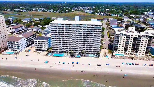 Drone / aerial view of a pool area, apartment complex, and a large body of water | Image 33