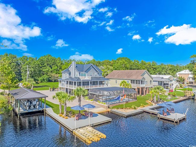 Dock area featuring a water view, boat lift, glass enclosure, a yard, and a patio | Image 5