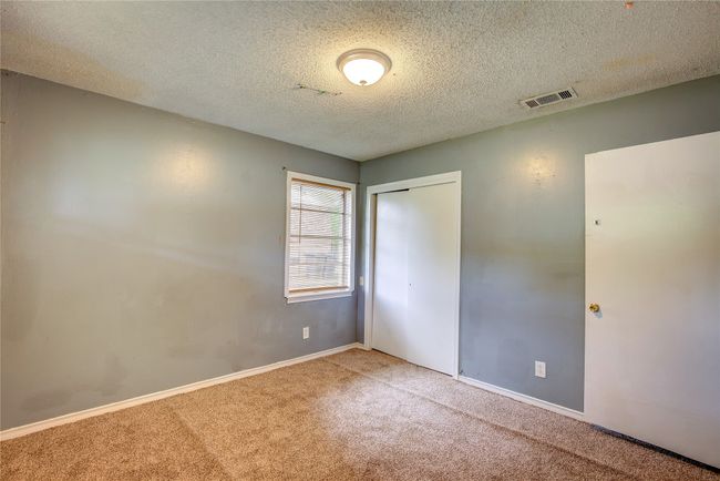 Unfurnished bedroom featuring carpet flooring, a closet, a textured ceiling, and baseboards | Image 20