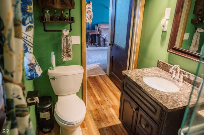 bathroom with toilet, vanity, and wood finished floors | Image 27