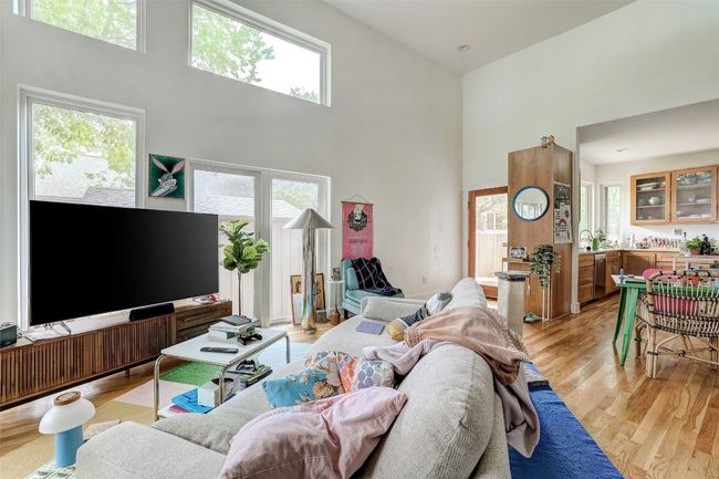 Living room with a high ceiling and light wood-style flooring | Image 33