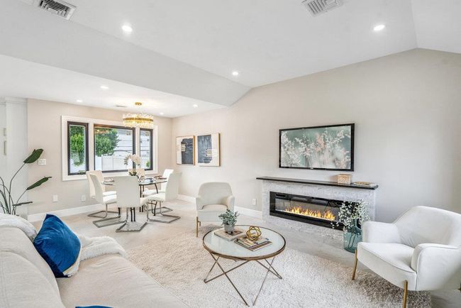 Living room with lofted ceiling, recessed lighting, a chandelier, and a glass covered fireplace | Image 18