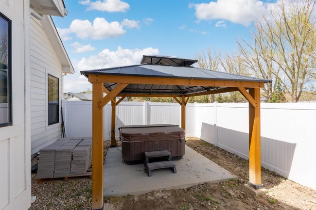 Fenced backyard with a hot tub, a gazebo, and a patio area | Image 36