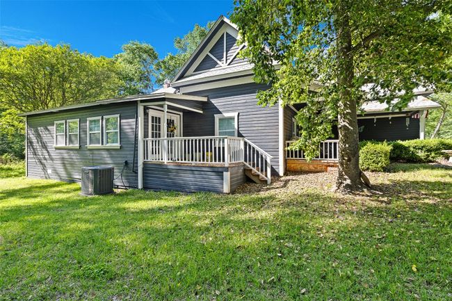 Back of home view with a backyard, front yard, and side yard central AC unit, and a deck | Image 36