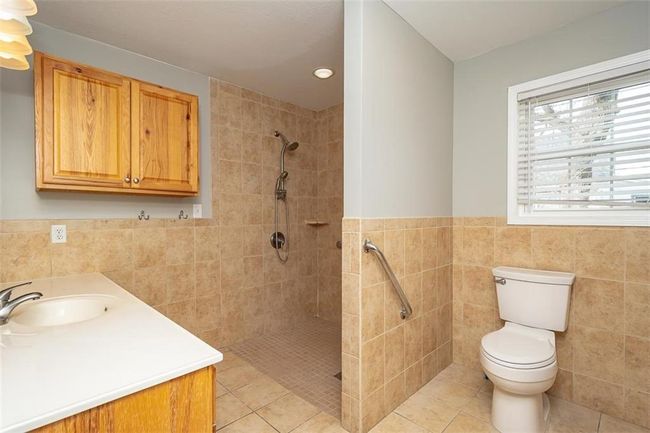 Bathroom featuring tile patterned flooring, tile walls, toilet, and tiled shower | Image 27