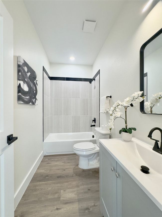 Full bath with toilet, vanity, shower / tub combination, and wood finished floors | Image 10