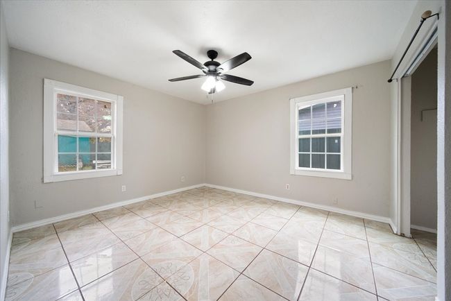 Unfurnished bedroom with ceiling fan and baseboards | Image 19