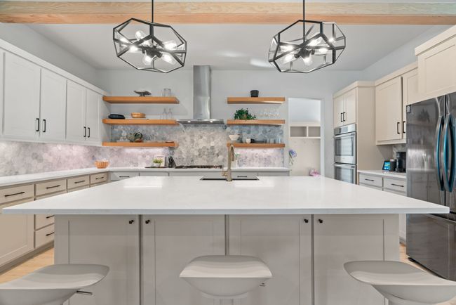 Kitchen with open shelves, wall chimney range hood, a chandelier, and appliances with stainless steel finishes | Image 16