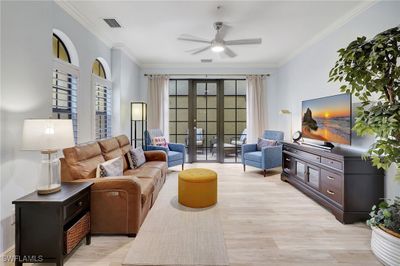 Living room with ceiling fan, light hardwood / wood-style floors, ornamental molding, and french doors | Image 3