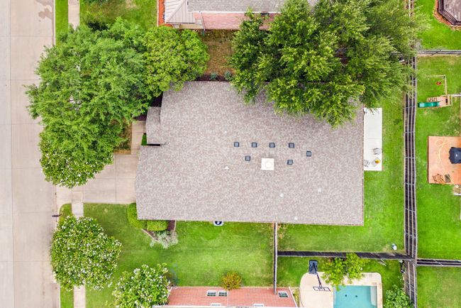 Rear view of the home with a clear look at the extended patio space and well-maintained lawn. | Image 37
