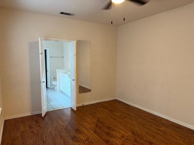 Unfurnished room with ceiling fan and dark wood finished floors | Image 11