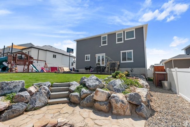 Rear view of house with a lawn, a playground, and fence | Image 25