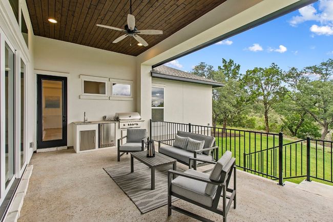 View of patio / terrace with a ceiling fan, an outdoor kitchen, an outdoor living space, and view of scattered trees | Image 29
